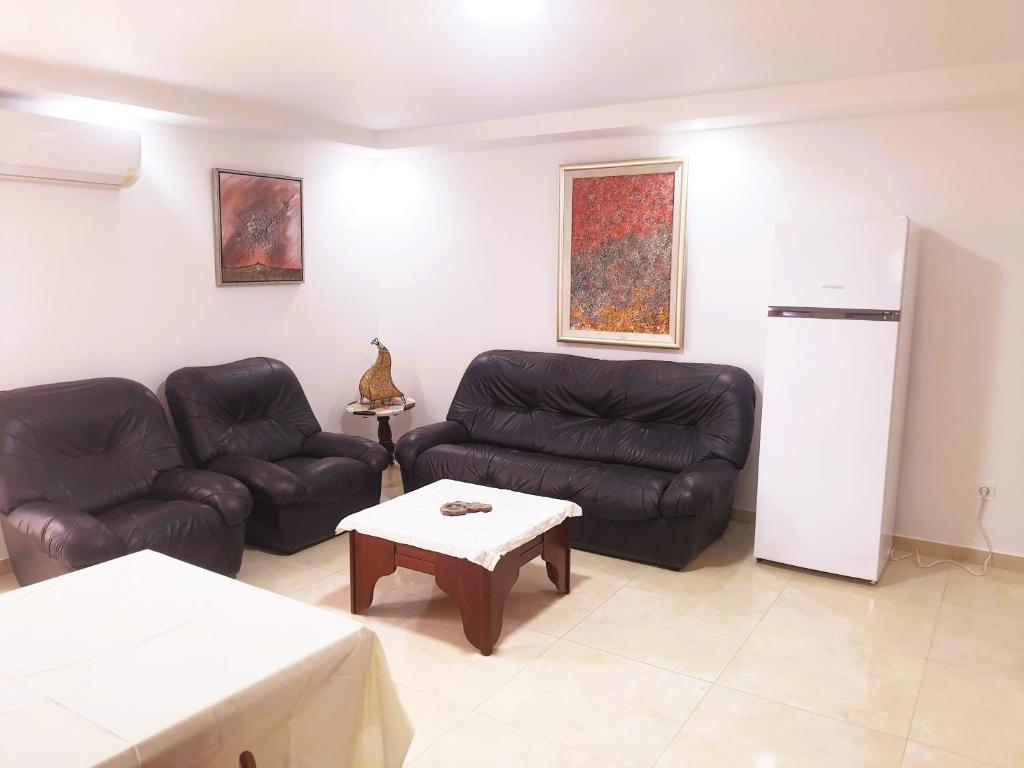 a living room with two leather couches and a table at Reposant in Bin Rhilouf