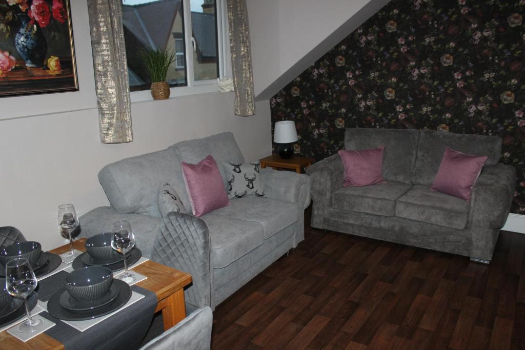 een woonkamer met 2 banken en paarse kussens bij Blackburn Heights Sleeps 4 Family Apartment in Bridlington