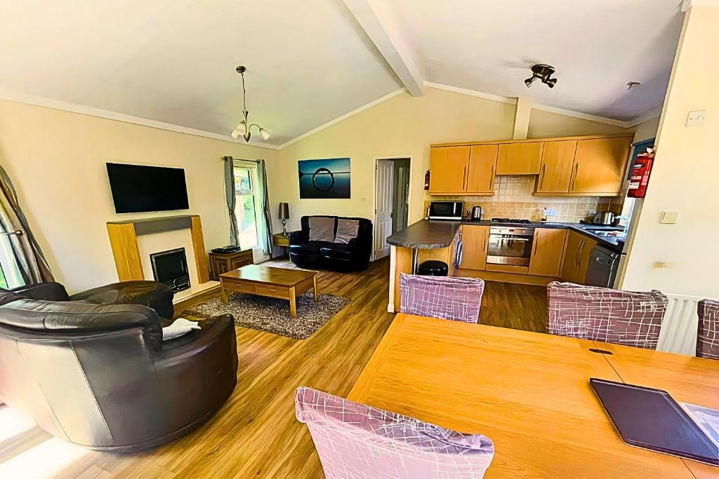 a living room with a couch and a table at Family Friendly Lodge sleeping 5 with Hot Tub - Devon in Chudleigh
