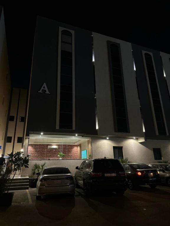a building with cars parked in a parking lot at night at Vant in Riyadh