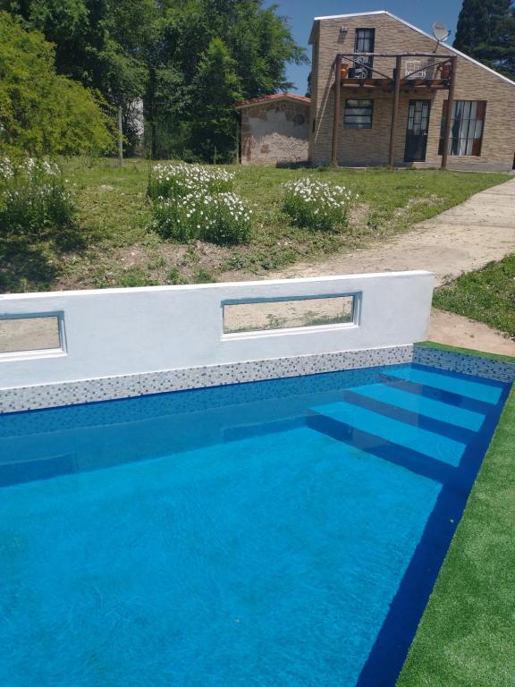 a blue swimming pool in front of a house at Turco in Villa Giardino