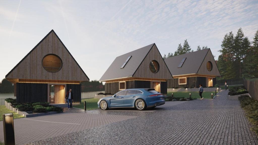a blue car parked in front of a house at Chaty Gorcovia in Nowy Targ