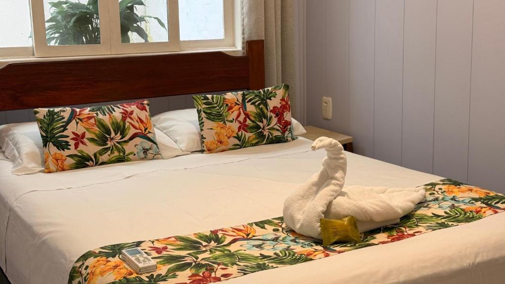 a white bird is sitting on a bed at Mares e Flores de Bombinhas in Bombinhas
