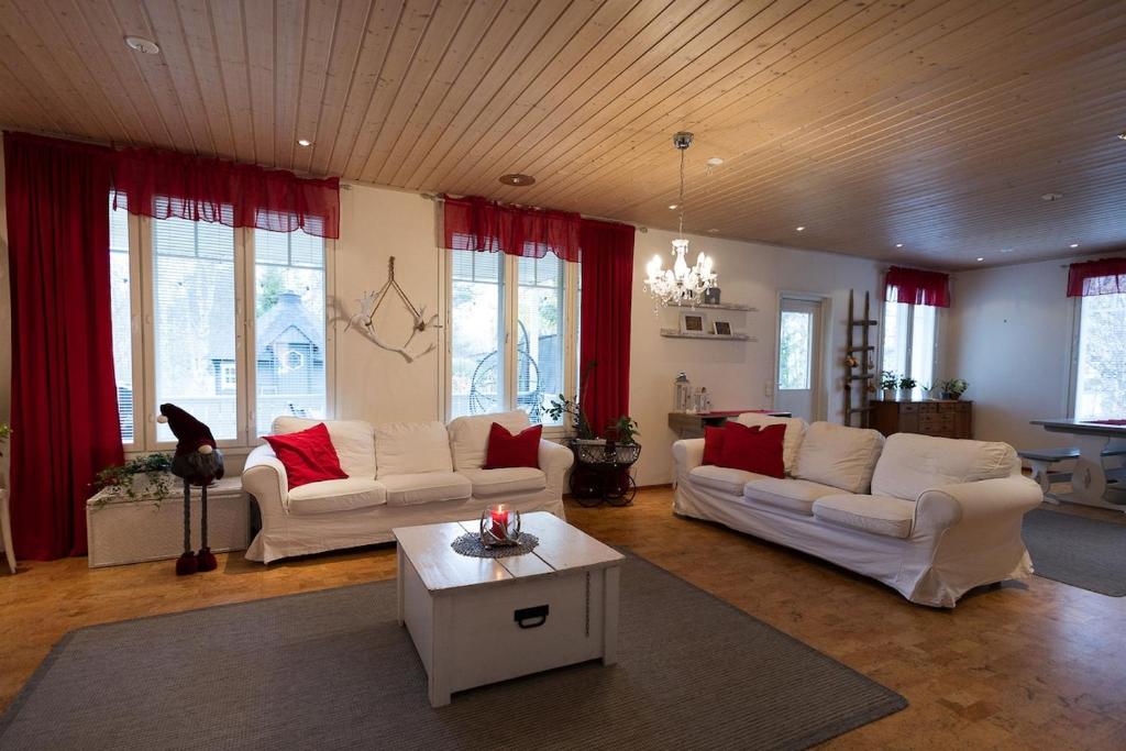 a living room with two white couches and a table at Spacious detached house for a larger group in Rovaniemi
