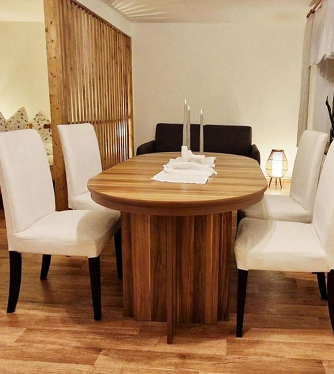 a wooden table with white chairs and a table with candles on it at Waitzdorfer Landhaus Pieper in Hohnstein