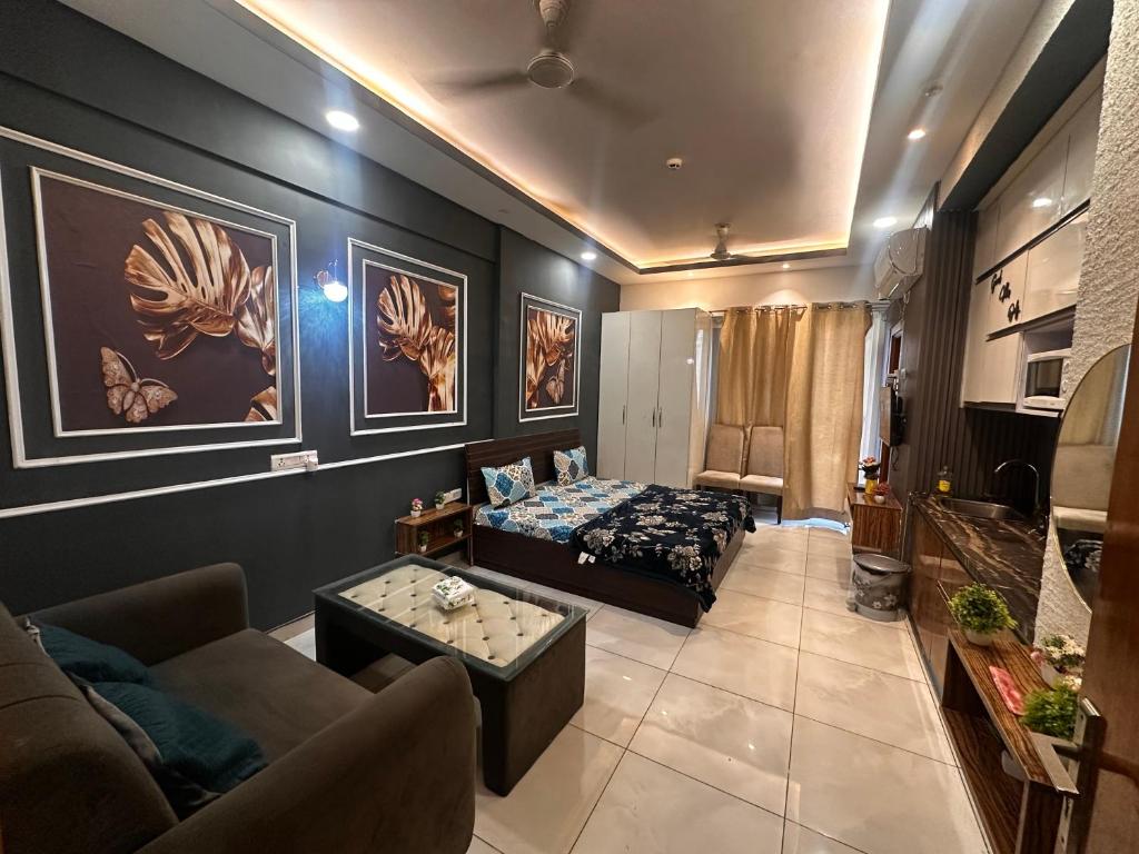 een woonkamer met een bank en een bed bij Bell Rooms Luxury studio Apartment in Noida