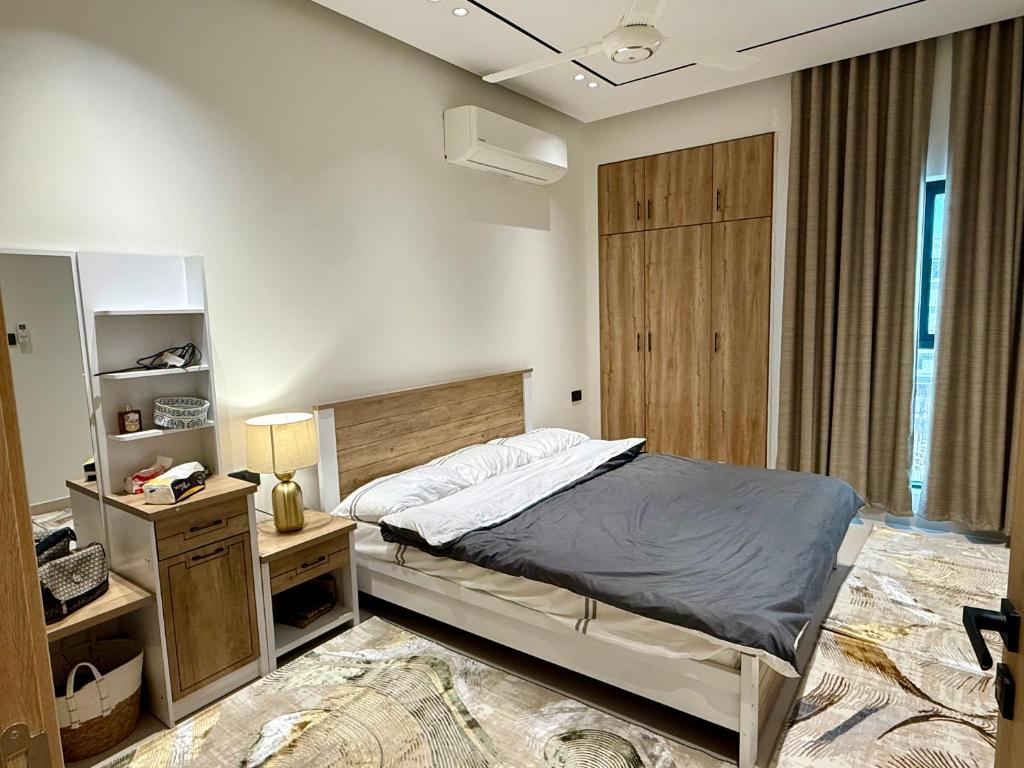 a bedroom with a bed with a wooden headboard at Al Furat Apartment in Seeb