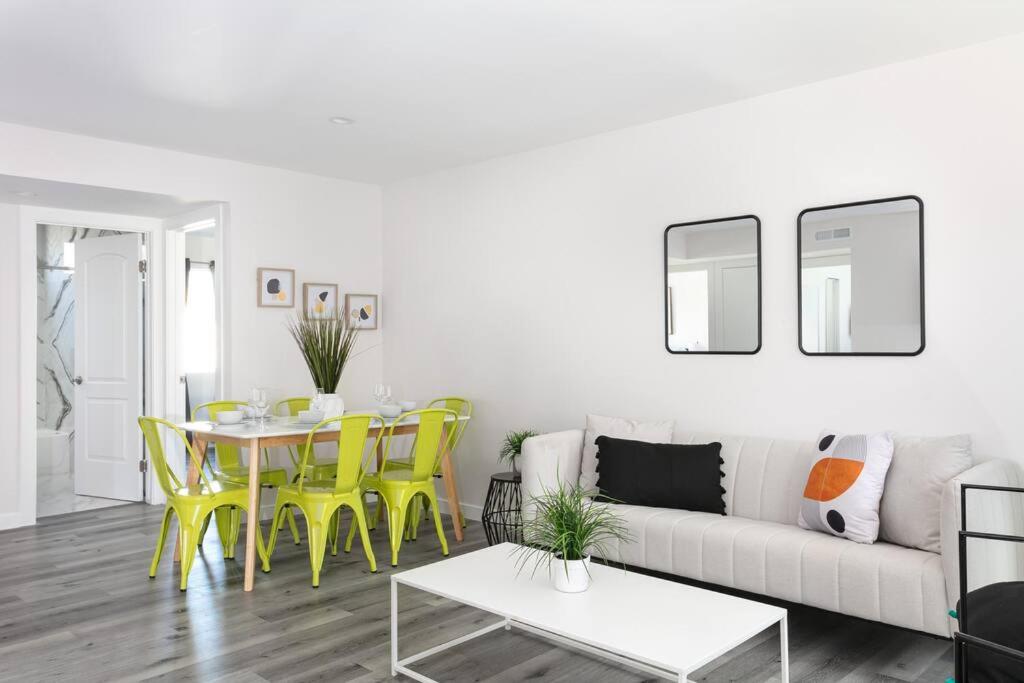 a living room with a couch and a table and yellow chairs at Central 3BR Apt Near Americana in Glendale