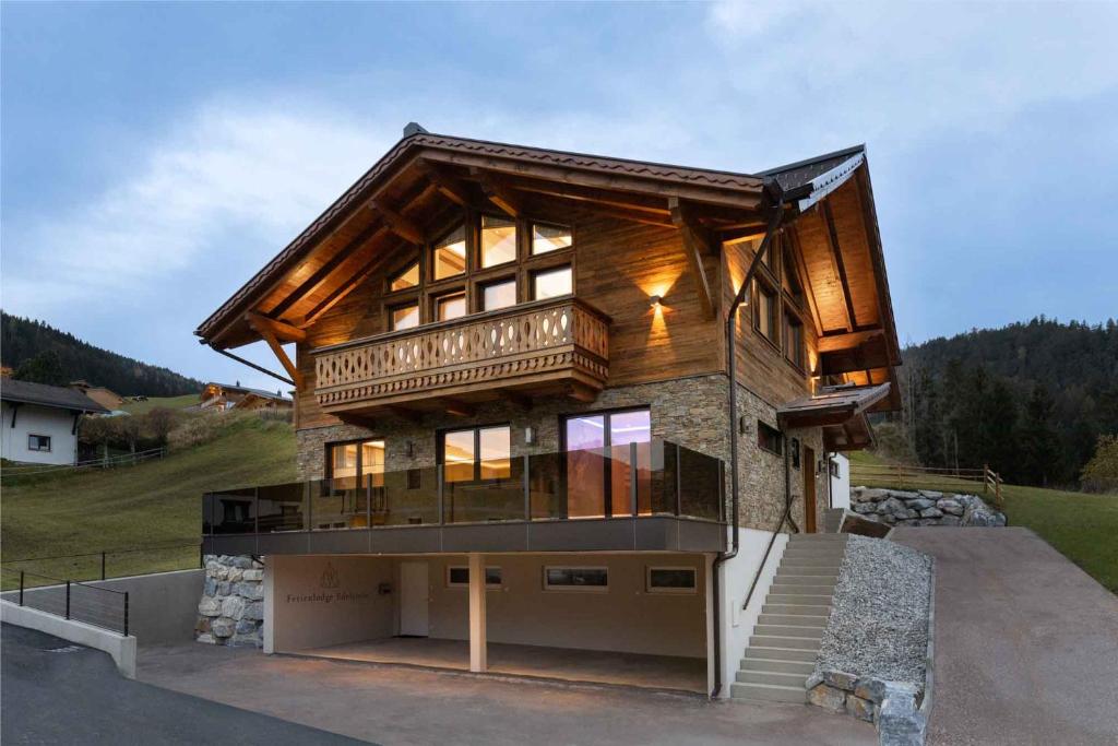a large wooden house with a balcony on top at Ferienlodge Edelstein in Forstau