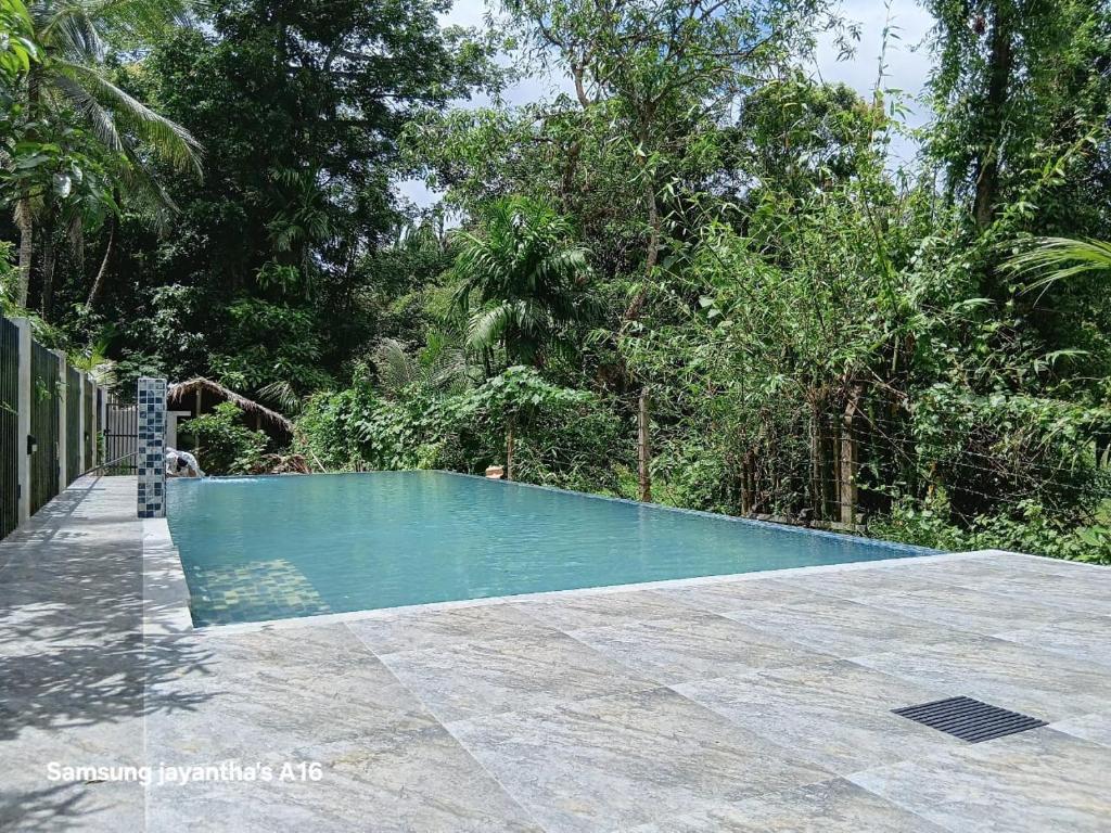 a swimming pool in the middle of a yard at The Garden Grove Villa in Yatiyana