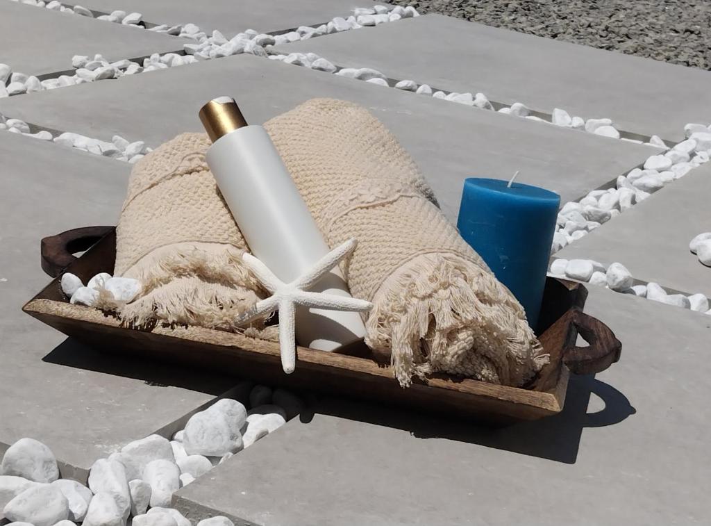 ein Korb mit einem Handtuch, einer Kerze und einem Seestern in der Unterkunft Leukos Home Relais Ecoretreat b&b in Diamante