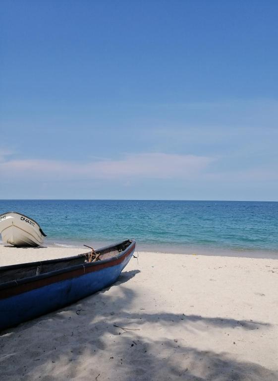 a boat sitting on a beach next to the ocean at SAMARIA Best luxury in Santa Marta