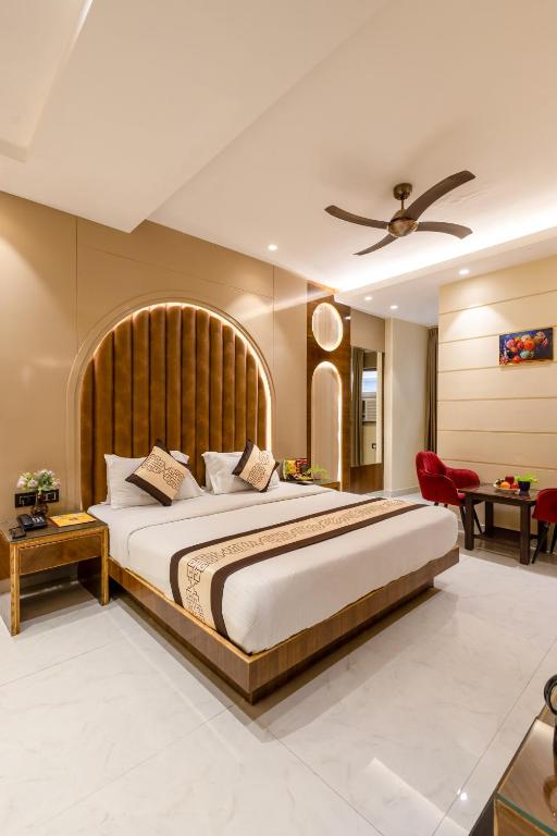 a bedroom with a large bed with a wooden headboard at Hotel Vanson Villa, City Centre - With Free Airport & Train Station Pickup in New Delhi