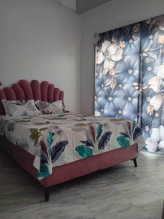 a bedroom with a bed with a red head board at Hergla Diamant Bleu 'Najla' in Hergla