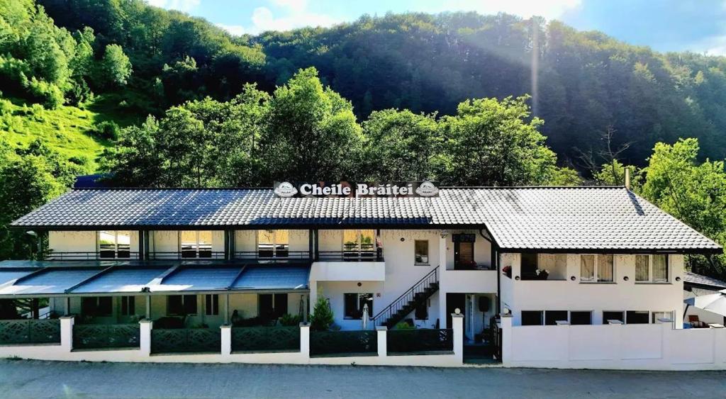 a hotel on the water with a mountain in the background at Cheile Braitei in Lupeni