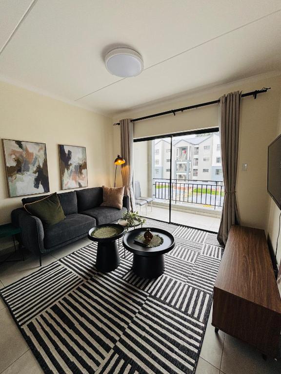 a living room with a couch and a large window at Right at home in Boksburg