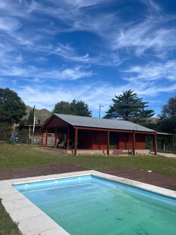a large swimming pool in front of a building at Cabañas del Valle in Huerta Grande