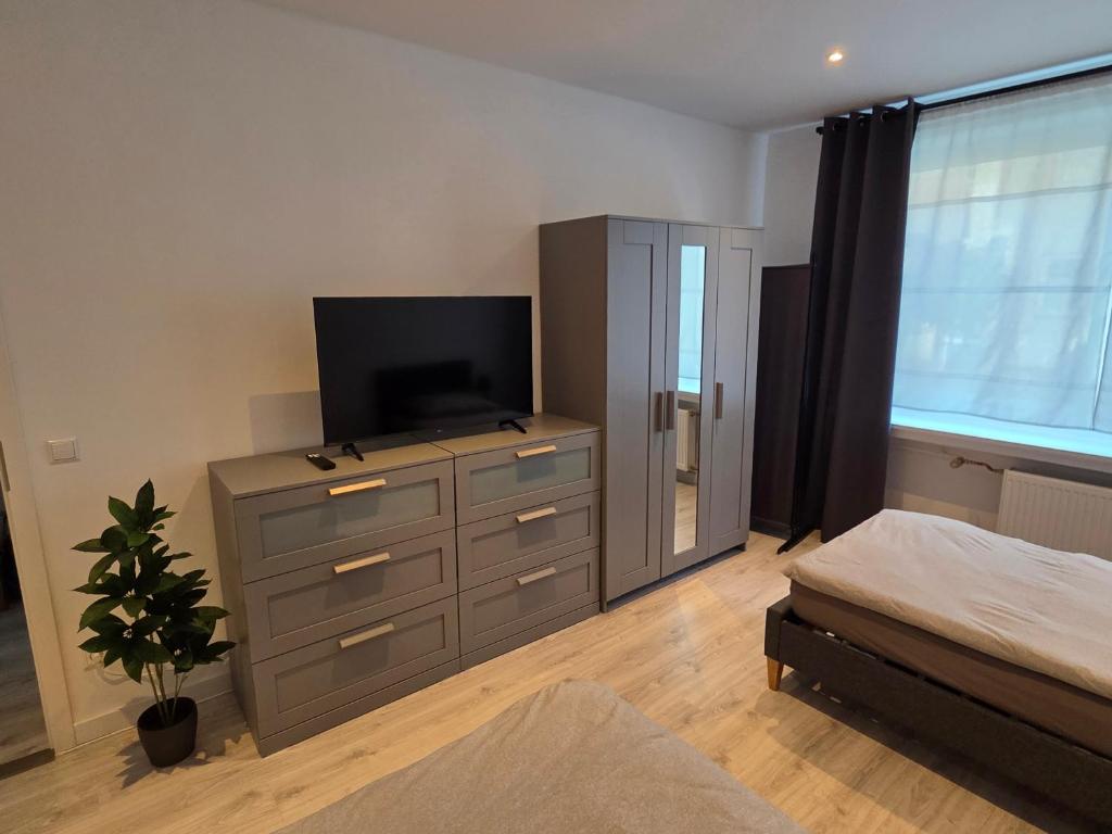 a bedroom with a dresser with a television on it at JONALU - saniert - zentral - voll ausgestattet - 4 Personen - TOP in Celle