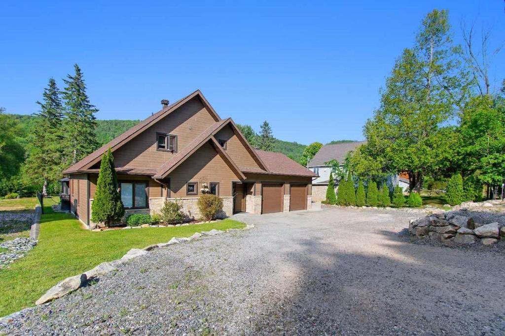 a large house with a driveway in front of it at Peaceful Retreat on Lac de l'Argile in Notre-Dame-de-la-Salette