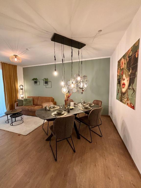a dining room with a table and chairs and a living room at Stilvolles Apartment 3 Zi Klinik & Kurpark Terrasse Parkplatz Barrierefrei in Bad Oeynhausen