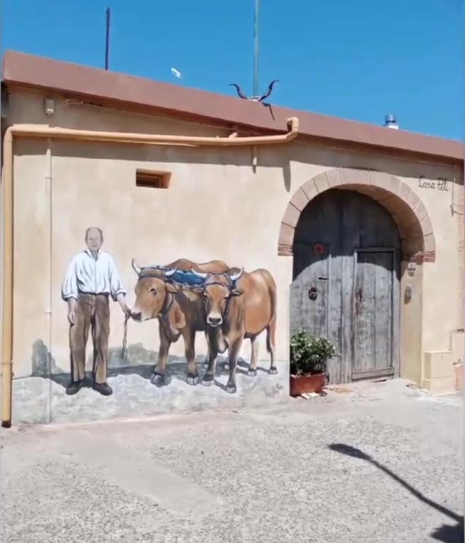 a painting of a man and two horses in front of a building at Casa Pili in San Vito