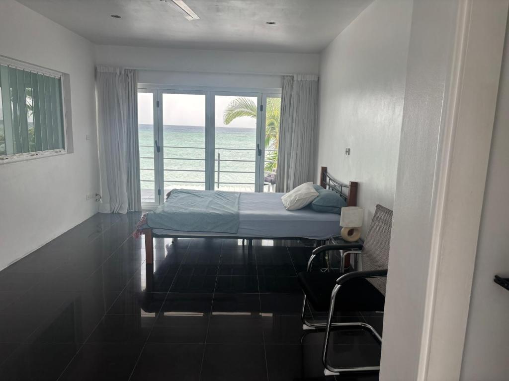 a bedroom with a bed and a view of the ocean at Casa Di george in Port Vila
