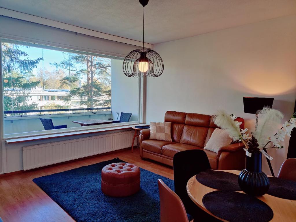 a living room with a couch and a table at Costal Stay with Forest Views in Helsinki