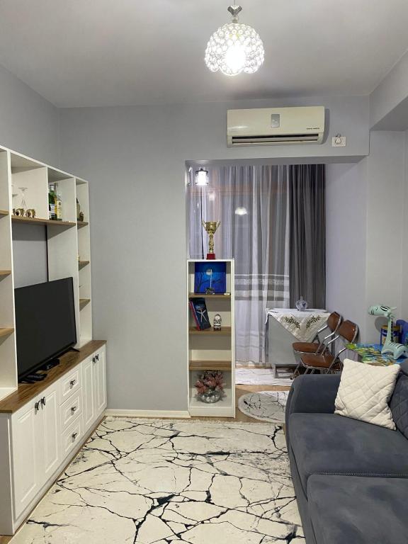 a living room with a couch and a television at One Bedroom Apartment Lake View Pogradec in Pogradec