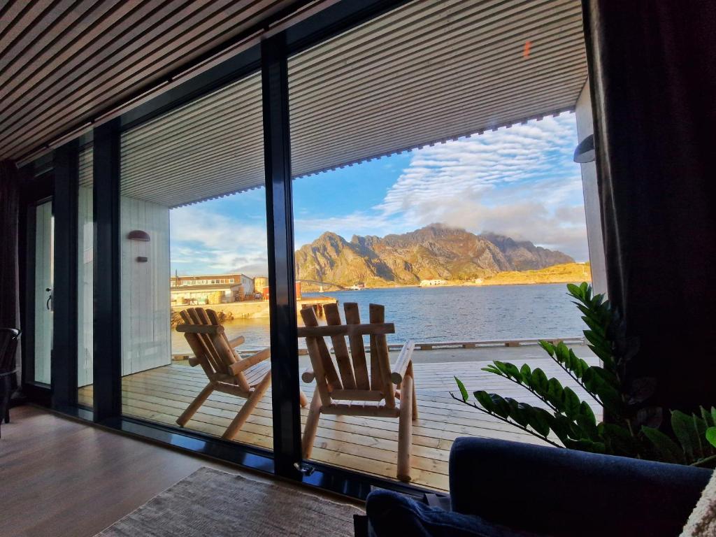 two chairs on a deck with a view of the water at Seafront apartment Henningsvær in Henningsvær