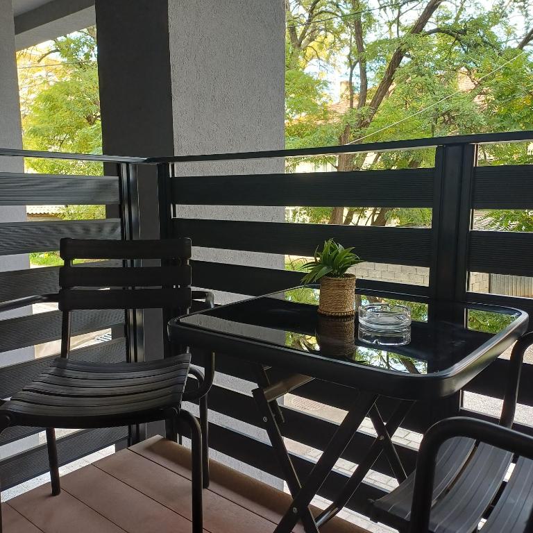 a black table and two chairs on a porch at Apartman Nikol in Kumanovo