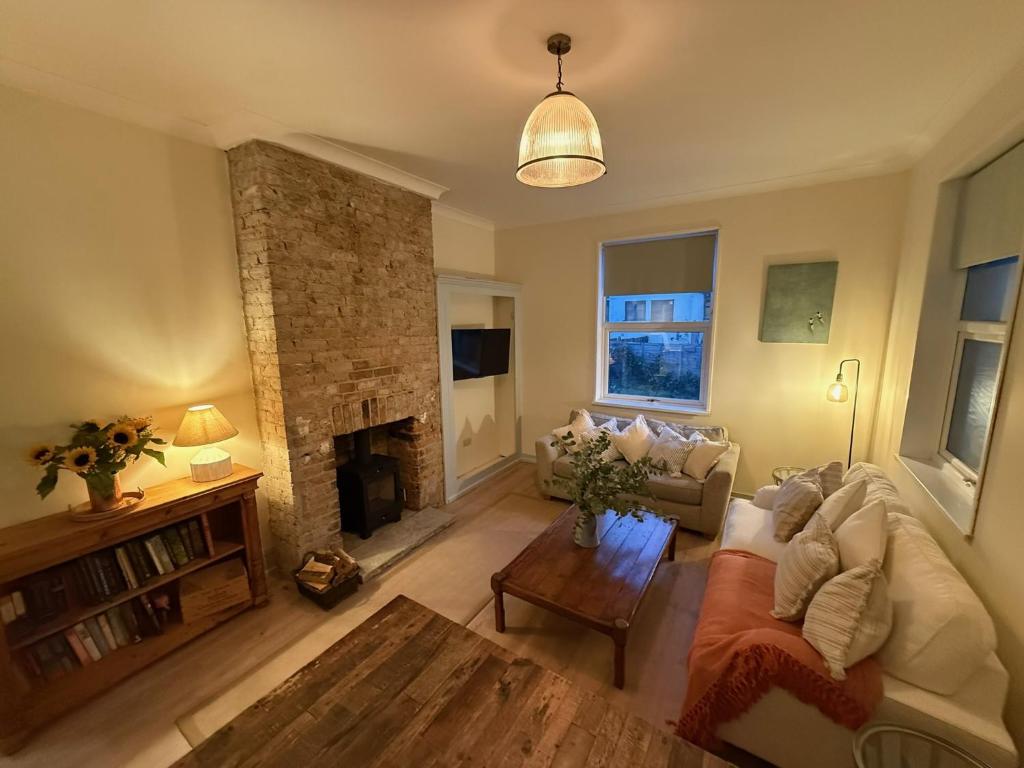 a living room with a couch and a fireplace at Beautiful Margate Retreat with Log burner, Garden, minutes to beach in Margate