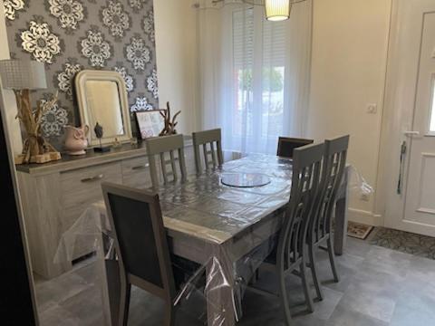 a dining room with a table and chairs and a mirror at Maison individuelle avec Jardinet in Arques-la-Bataille