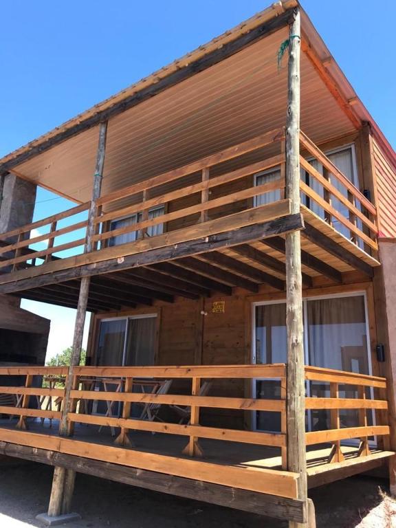 a large wooden house with a wrap around porch at Santo Descanso in Punta Del Diablo