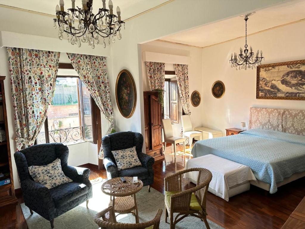 a bedroom with a bed and two chairs at Catherine's Home in Rome