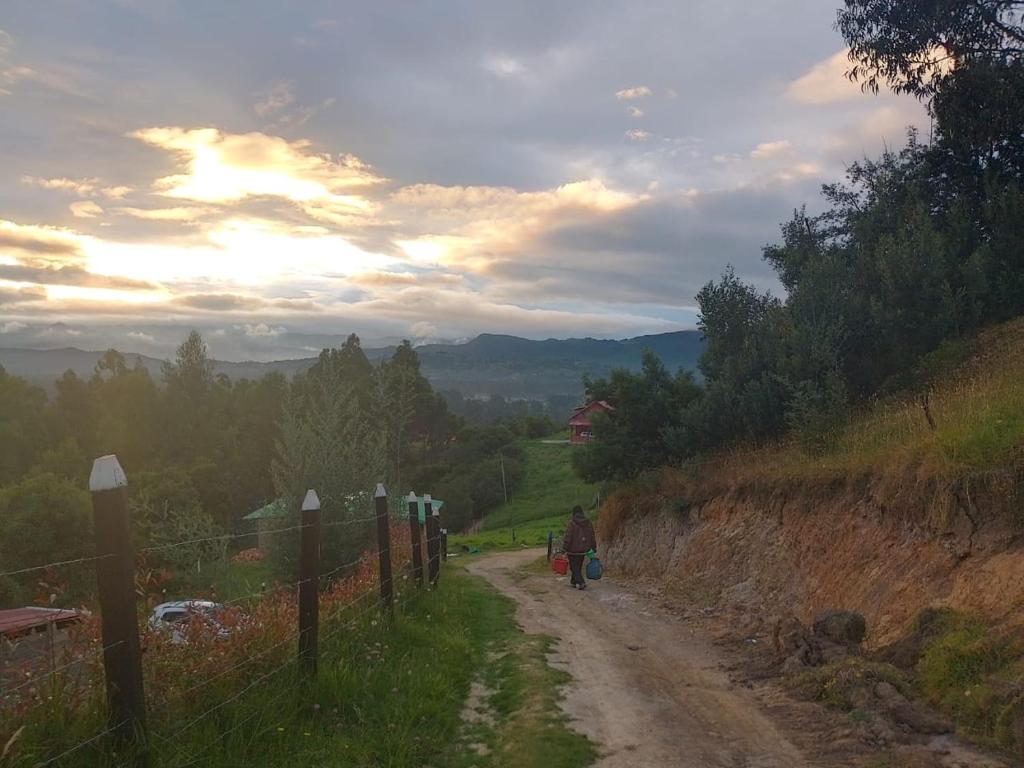 にあるCamping Nuevo Amanecerの未舗装の道を歩いている人