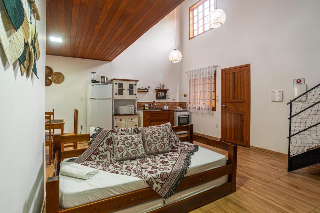 a living room with a bed and a kitchen at BC Praia Estaleiro - 2 Vagas, Ar, Churras e Pet OK in Balneário Camboriú