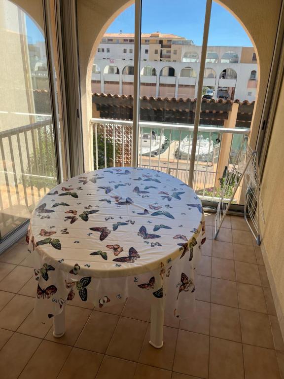 einen weißen Tisch in einem Zimmer mit Fenster in der Unterkunft séjour d'exception face a la marina et plage à 100m in Sète