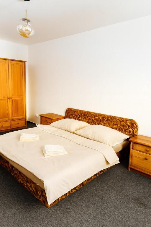 a bedroom with a large bed and wooden furniture at Apartmán 13 in Otilia
