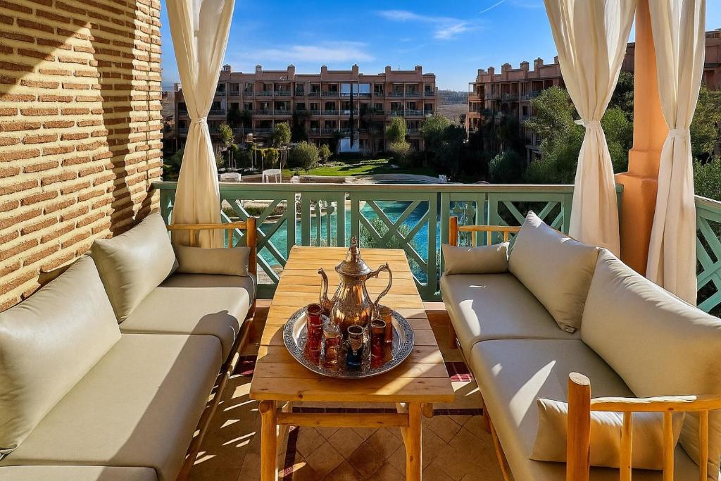 マラケシュにあるModern - Moroccan 2BR with Panoramic Pool Viewのパティオ(ソファ、テーブル付)