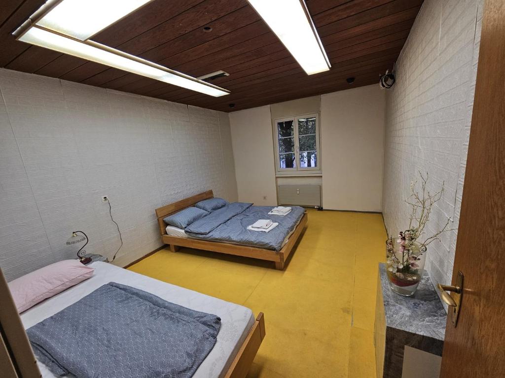 a room with two beds in it with a window at Privatzimmer -Venus- mit gemeinsamer Küche und Bad in der Altstadt Chur in Chur