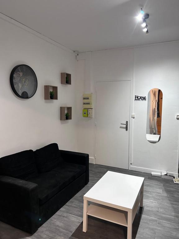 ダンケルクにあるLe Dunkerquois - Appartement moderne et tout équipéのリビングルーム(黒いソファ、白いテーブル付)