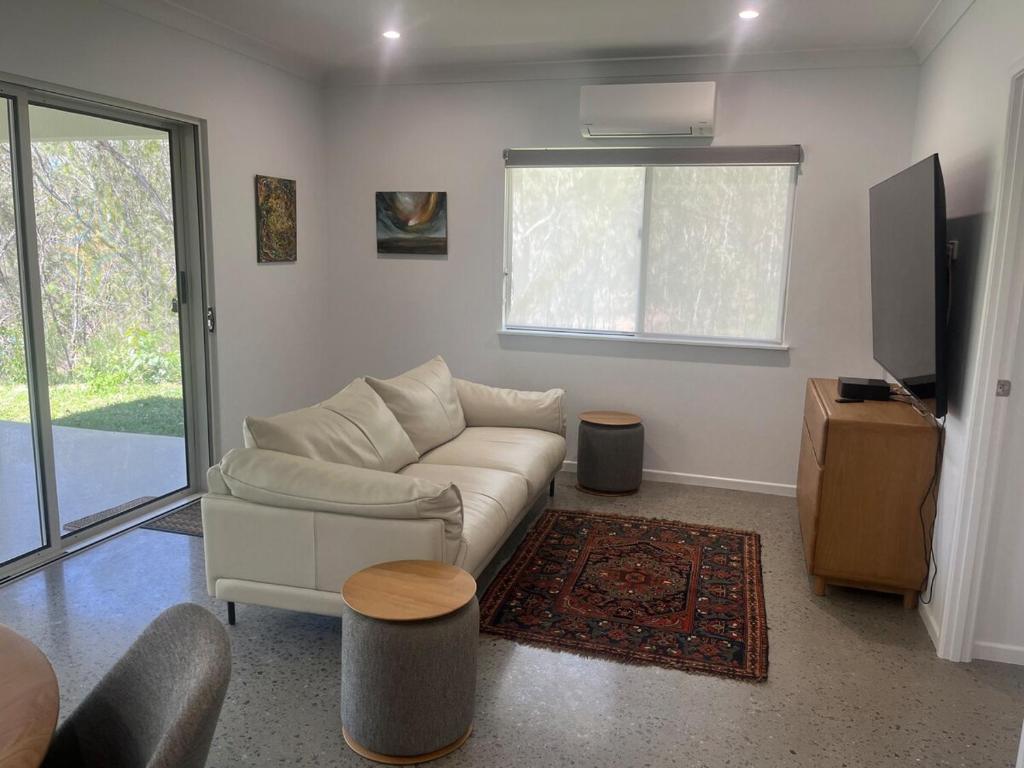 ein Wohnzimmer mit Sofa und Fernseher in der Unterkunft Koah Private hideaway with creek access 