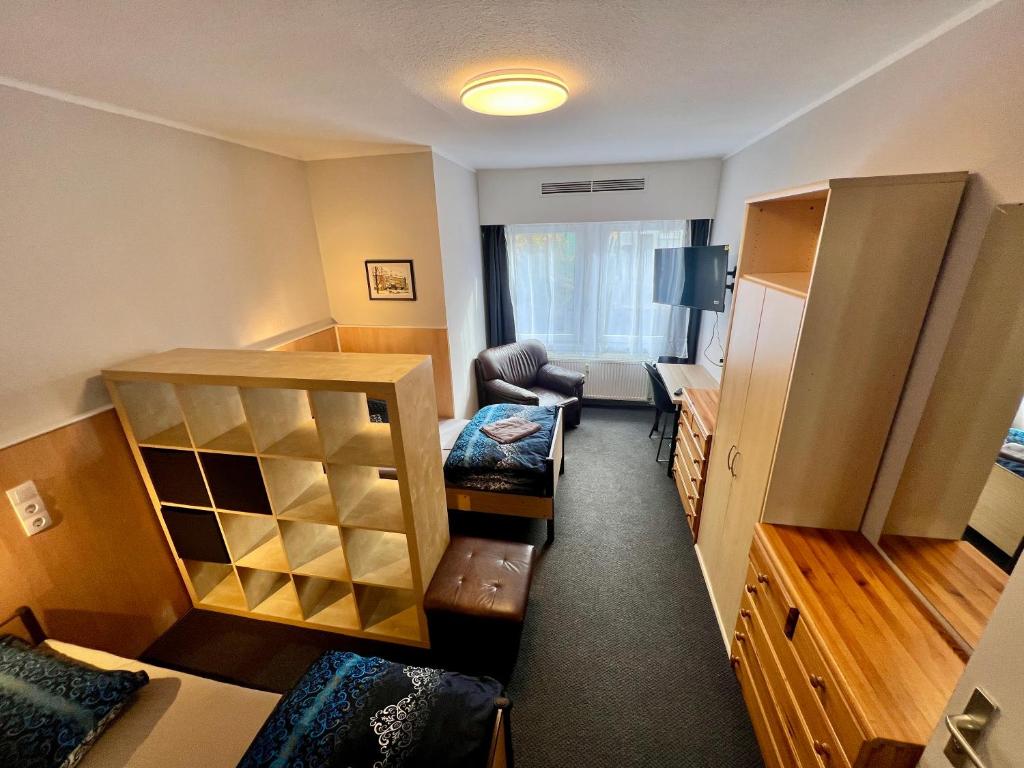 a room with a living room with a couch and a chair at Pension BettMan Erfurt in Erfurt