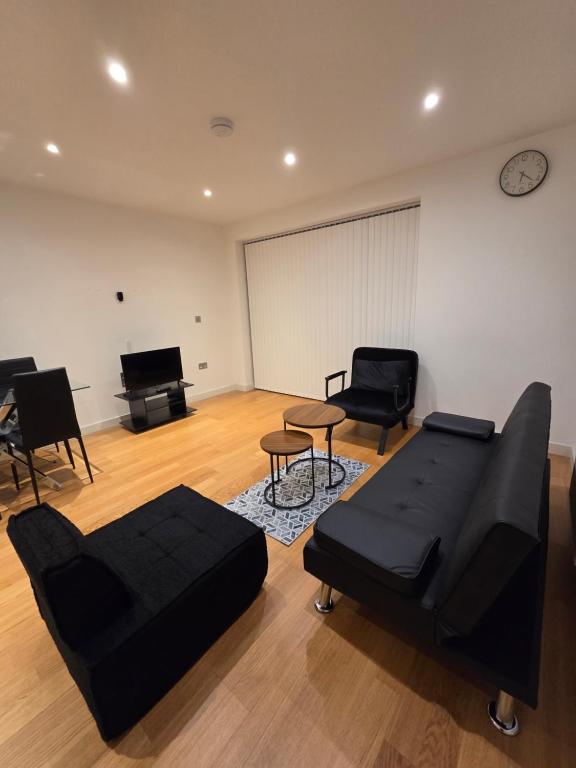 a living room with a couch and chairs and a piano at City Gateway Apartment - Green Quarter Southall Retreat in Southall