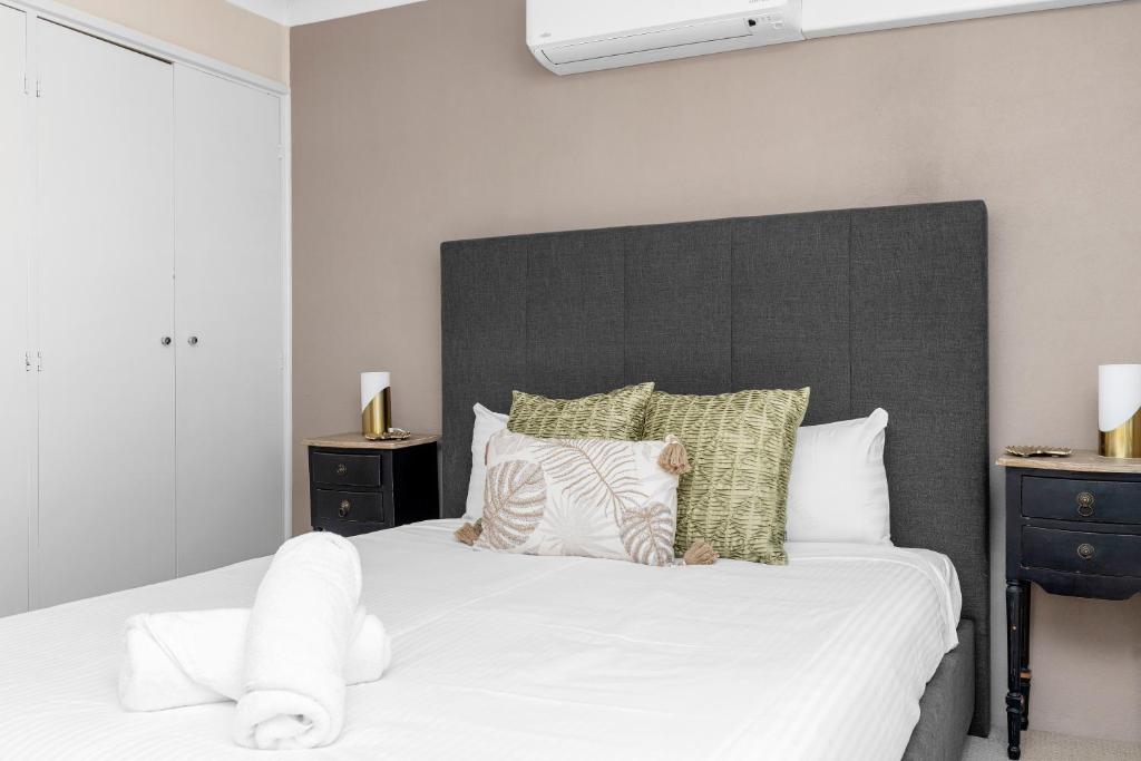 a bedroom with a large bed with white sheets and pillows at Wagga Central Apartments in Wagga Wagga
