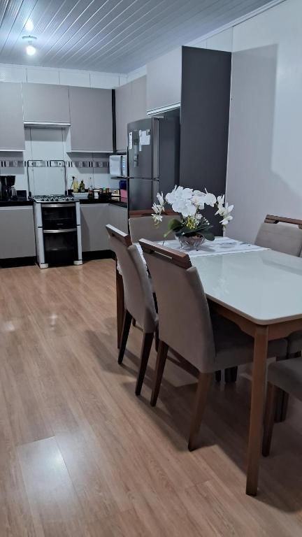 a dining room with a table and chairs and a kitchen at Casa 5 estrelas in Cascavel