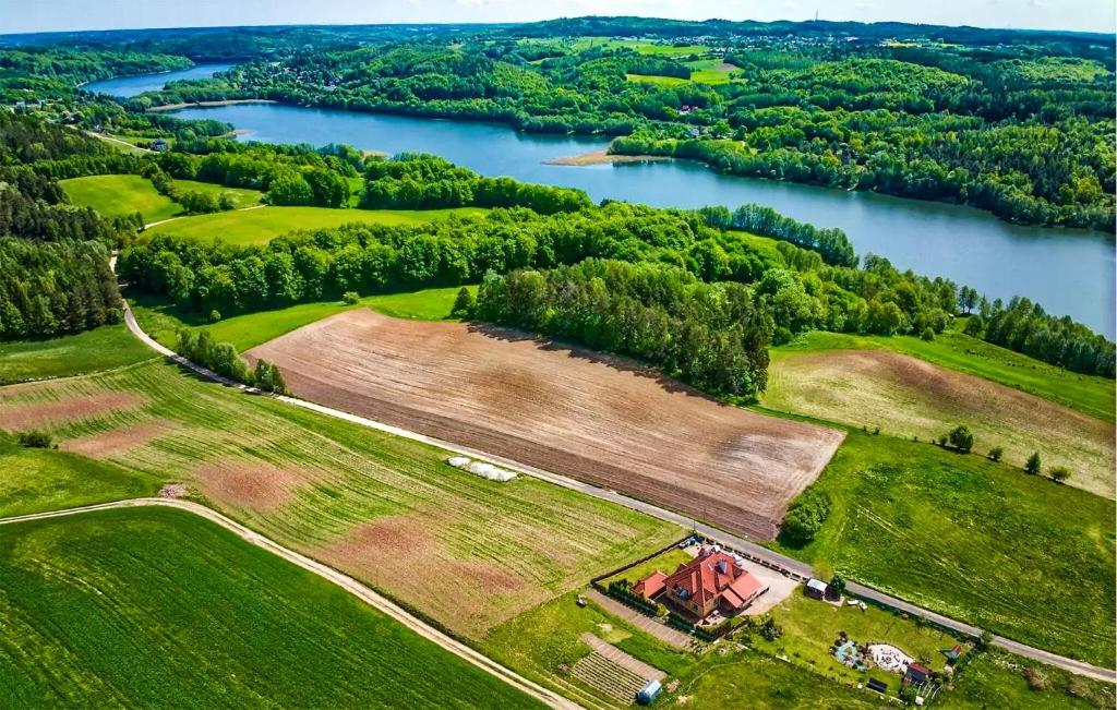 einen Luftblick auf einen Bauernhof und einen See in der Unterkunft 1 Bedroom Stunning Apartment In Golubie in Pierszczewo