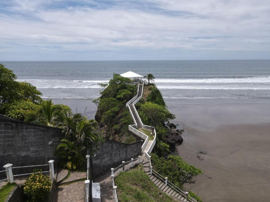 a stairway leading down to a beach with the ocean at Hotel Rancho Infinito in El Cuco