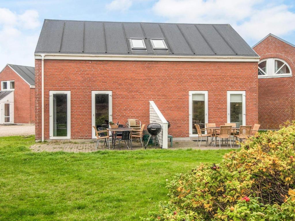 una casa de ladrillo rojo con mesa y sillas en 6 person holiday home in Rømø, en Sønderby