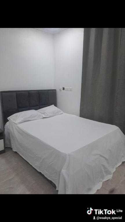 Cette chambre comprend un grand lit blanc. dans l'établissement Meg place, à Amamoli